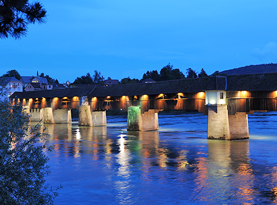 Blick übers Wasser auf das Ringhotel Goldener Knopf bei Nacht