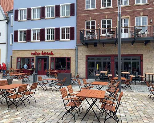 Atemraubender Restaurant-Außenbereich auf dem Marktplatz in Rheine mit gemütlichen Sitzmöglichkeiten.