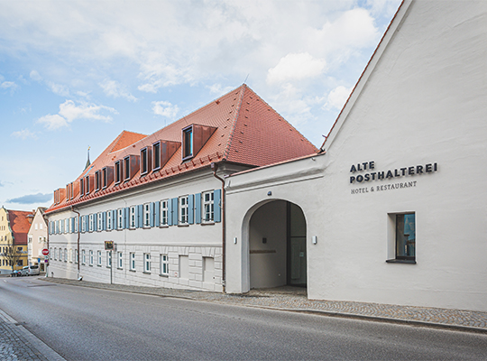 Terasse der alten Posthalterei. Im Innenhof stehen braune Holztische und Holzstühle.